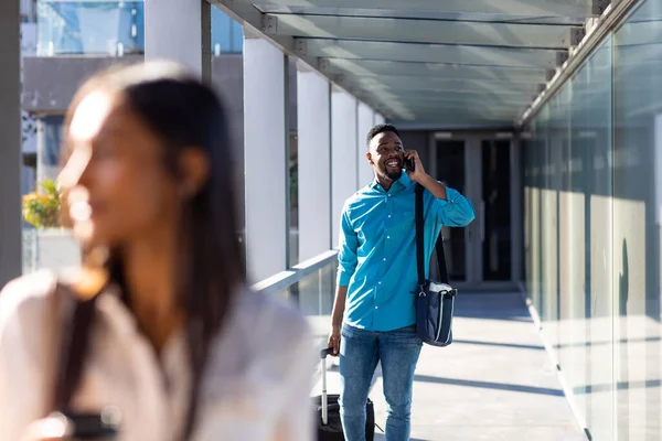 Χαμογελώντας Αφροαμερικανός Επιχειρηματίας Αποσκευές Μιλώντας Στο Κινητό Τηλέφωνο Στο Διάδρομο — Φωτογραφία Αρχείου