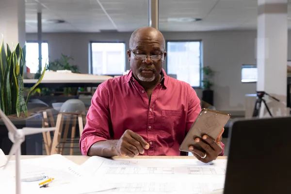 Mature African American Engineer Holding Digital Tablet While Analyzing Blueprint — Stock Photo, Image