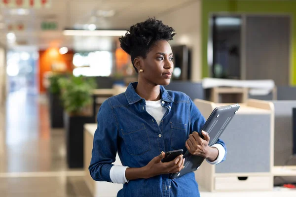 Młoda Afrykańska Bizneswoman Trzymająca Smartfona Laptopa Dala Miejsca Pracy Niezmienione — Zdjęcie stockowe