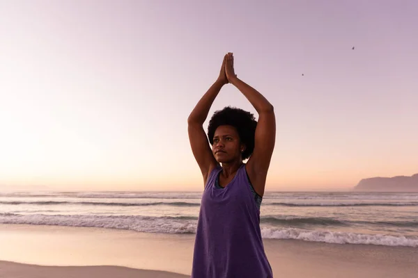 Afroamerykanka Dojrzała Kobieta Podniesionymi Ramionami Ćwicząca Plaży Przeciwko Bezchmurnemu Niebu — Zdjęcie stockowe