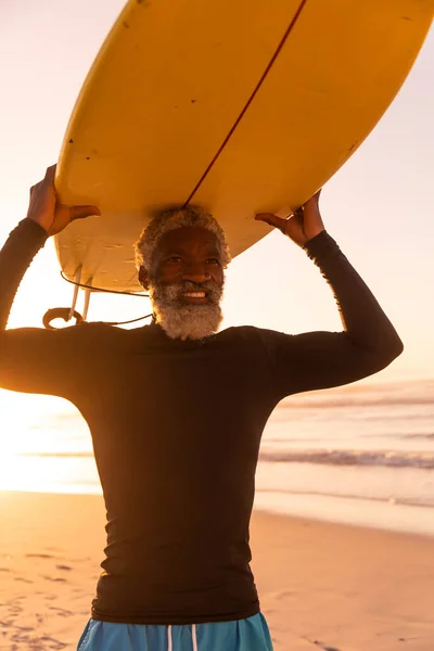 Lachende Afrikaanse Amerikaanse Senior Man Die Surfplank Hoofd Tegen Zee — Stockfoto