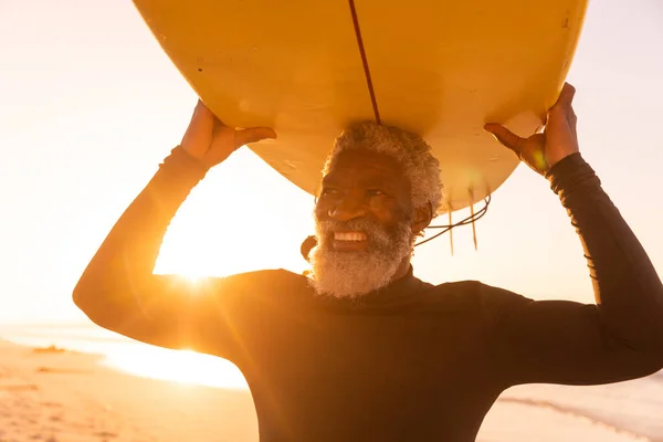 Усміхнений Афроамериканський Старший Чоловік Носить Серфінг Голові Пляжі Проти Чистого — стокове фото