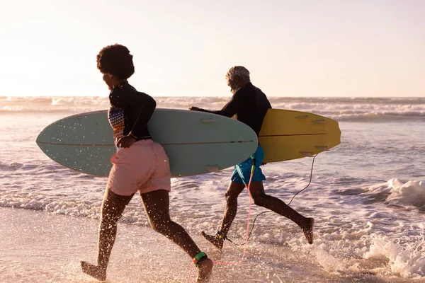 Fröhliches Afrikanisch Amerikanisches Paar Mit Surfbrettern Meer Vor Klarem Himmel — Stockfoto