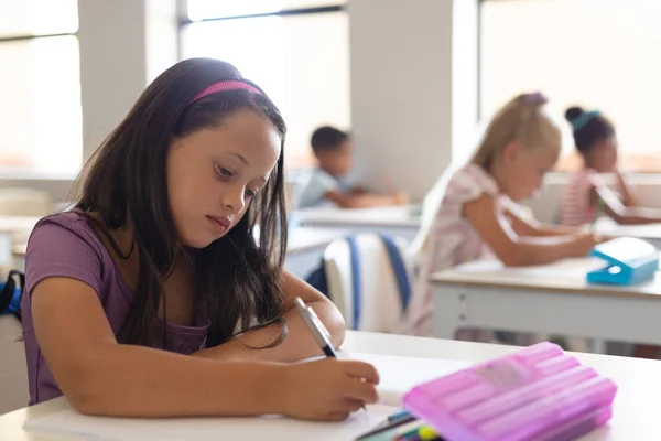 Colegiala Primaria Caucásica Escribiendo Libro Mientras Estudia Escritorio Aula Inalterado —  Fotos de Stock