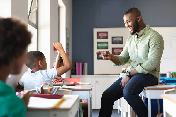 아프리카 미국인젊은 교사가 책상에 아프리카 미국인 초등학생에게 몸짓을 있습니다 변경되지 — 스톡 사진