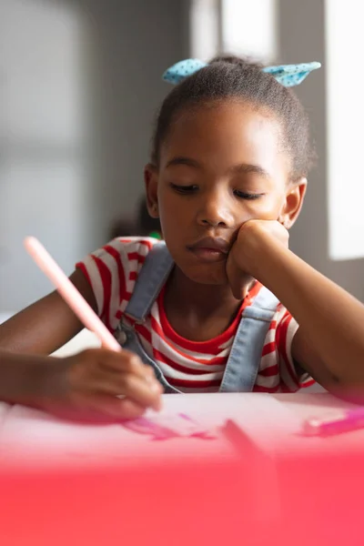 教室の机の上に本を書いているアフリカ系アメリカ人の小学生のクローズアップ 無修正 子供時代 学校のコンセプト — ストック写真