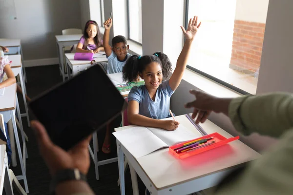 非洲裔美国年轻的男教师 带着数码平板电脑 把矛头指向书桌旁的小学女生 技术和学校概念 — 图库照片