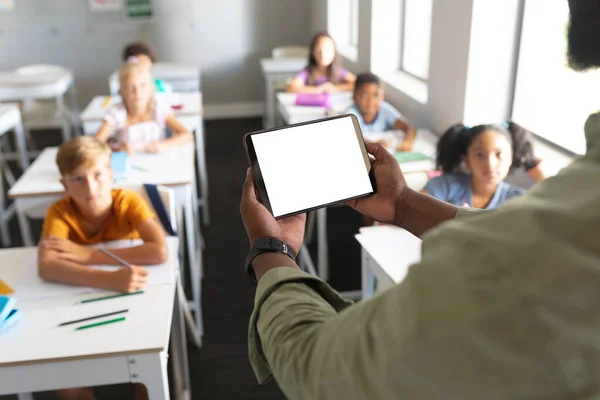 Profesor Joven Afroamericano Sosteniendo Tableta Digital Mientras Enseña Estudiantes Multirraciales —  Fotos de Stock