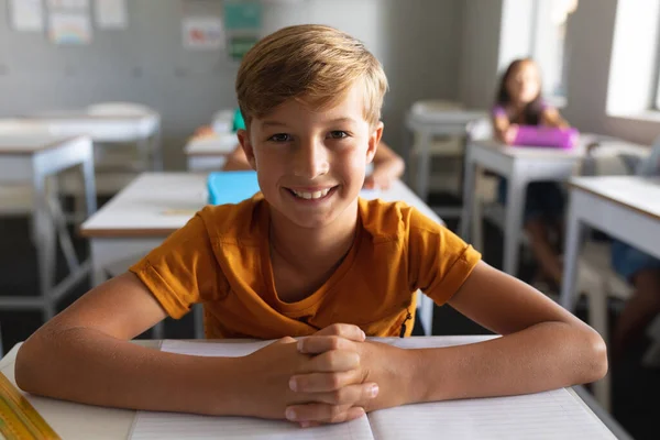 Potret Tersenyum Anak Kaukasia Dengan Tangan Tergenggam Duduk Meja Kelas — Stok Foto