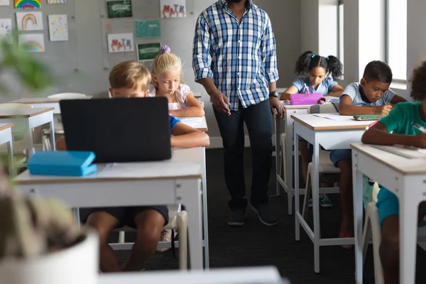 非洲裔美国年轻男教师的中段 由在课堂上学习的多种族学生组成 技术和学校概念 — 图库照片