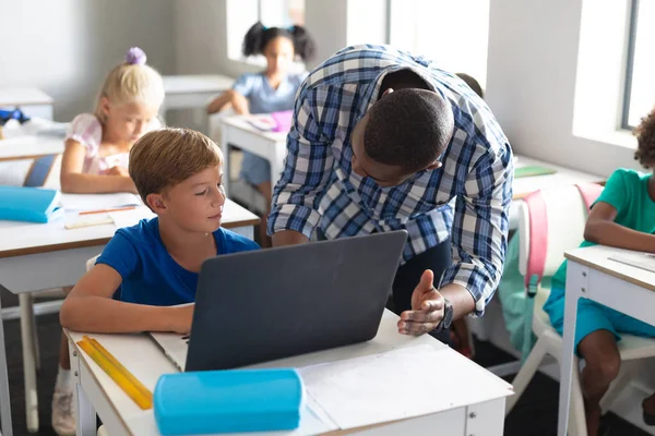 Profesor Joven Afroamericano Enseñando Portátil Colegial Primaria Caucásica Escritorio Inalterado — Foto de Stock