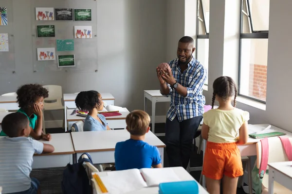 脳モデルを示すアフリカ系アメリカ人の若い男性教師を見ている多人種の小学生 変化のない教育子供時代教育科学システム学校の概念 — ストック写真