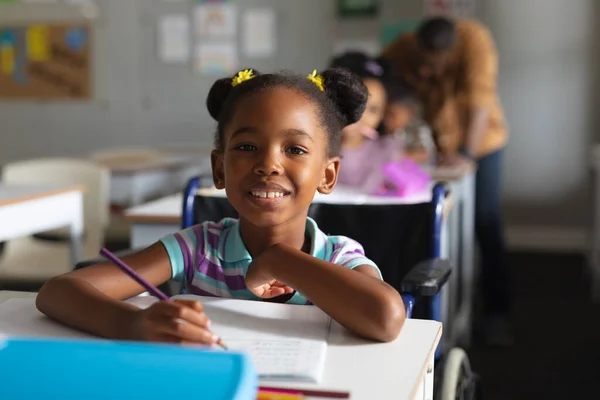 Retrato Menina Elementar Afro Americana Sorridente Estudando Enquanto Estava Sentada — Fotografia de Stock