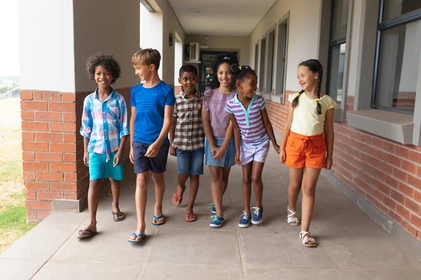 Повна Тривалість Усміхнених Багаторасових Учнів Початкової Школи Ходять Шкільному Коридорі — стокове фото
