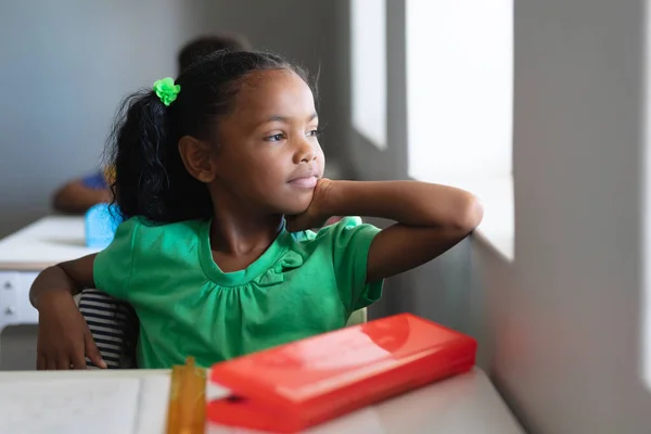 Düşünceli Afro Amerikan Ilkokul Öğrencisi Sınıfta Otururken Pencereden Bakıyor Değiştirilmemiş — Stok fotoğraf