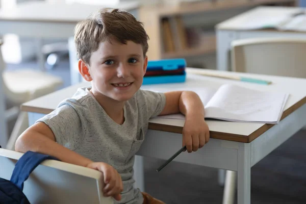 Portret Van Een Schattige Glimlachende Blanke Basisschooljongen Aan Een Bureau — Stockfoto