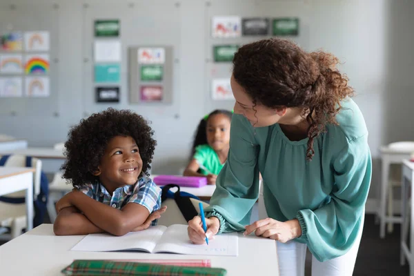 Caucasiana Jovem Professora Ensinando Afro Americana Elementar Estudante Estudando Mesa — Fotografia de Stock