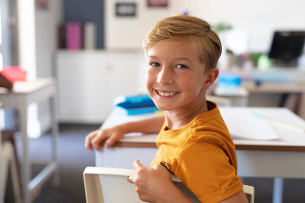 Portrait Smiling Caucasian Elementary Schoolboy Sitting Desk Classroom Unaltered Education Stock Picture