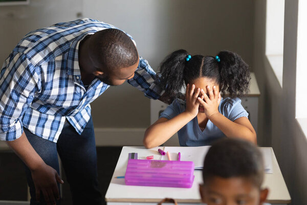 African American Young Male Teacher Consoling Sad Biracial Elementary Schoolgirl Royalty Free Stock Photos