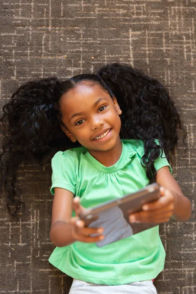 Retrato Cabeza Niña Afroamericana Primaria Con Tableta Digital Acostada Alfombra —  Fotos de Stock