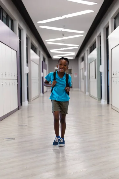 Πορτρέτο Του Χαμογελαστού Αφροαμερικανού Δημοτικού Σχολείου Σακίδιο Περπάτημα Στο Διάδρομο — Φωτογραφία Αρχείου
