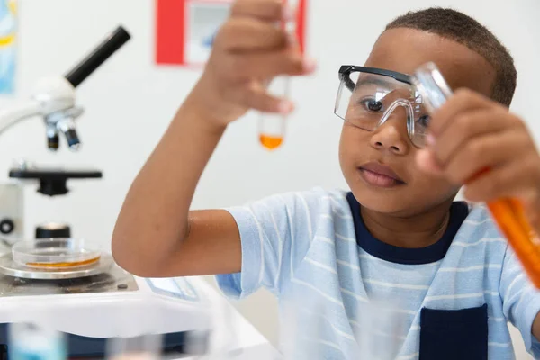 Ragazzo Elementare Afroamericano Che Guarda Sostanza Chimica Arancione Provetta Durante — Foto Stock