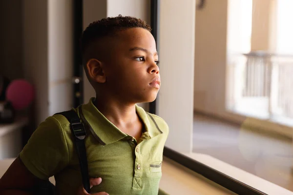 Ragazzo Delle Elementari Afroamericane Pensieroso Piedi Vicino Alla Finestra Mentre — Foto Stock