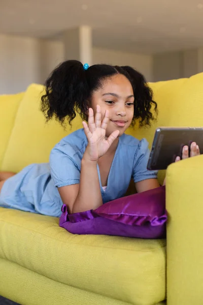 Biracial Elementär Flicka Viftar Över Smart Telefon Videosamtal När Ligger — Stockfoto