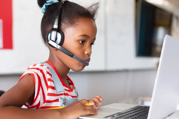 Close African American Elementary Schoolgirl Wearing Headphones While Using Laptop — Stock Photo, Image