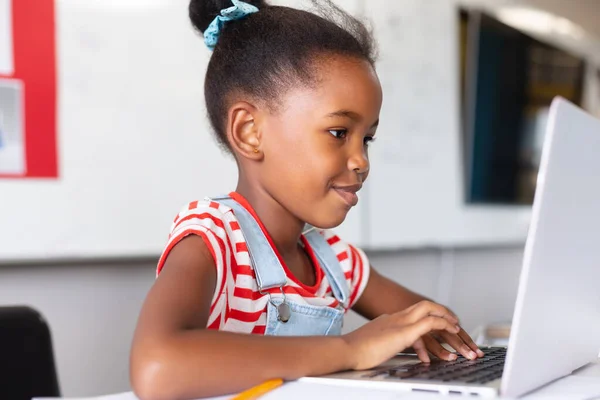 Leende Afrikansk Amerikansk Grundskoleflicka Som Använder Laptop Vid Skrivbordet Medan — Stockfoto