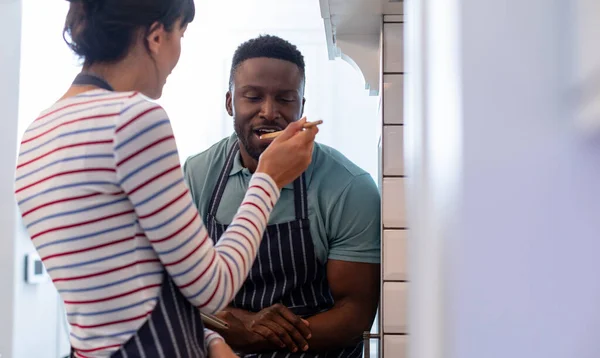白人の若い女性がアフリカ系アメリカ人のボーイフレンドに食事を与えている 変わることのない ライフスタイル 食べ物 家庭生活 食べ物の準備 — ストック写真