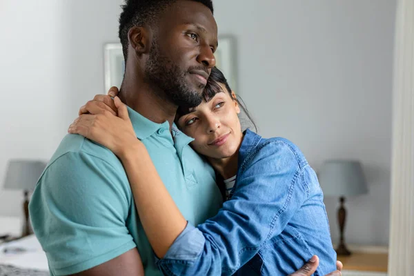 多人種の若い夫婦が家に立っている間に抱き合っている 変わらないライフスタイル国内生活団結愛熟考 — ストック写真