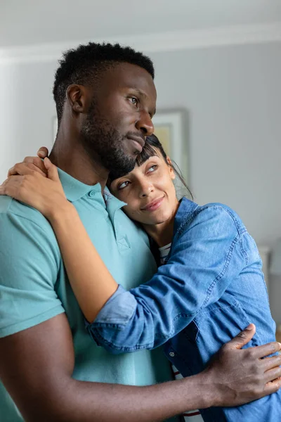 有思想的多种族年轻夫妇在家中的客厅里拥抱时 目光移开 不变的 不变的生活方式 家庭生活 — 图库照片