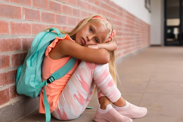 Portrait Caucasian Elementary Schoolgirl Backpack Sitting Floor School Corridor Unaltered — Stock Photo, Image