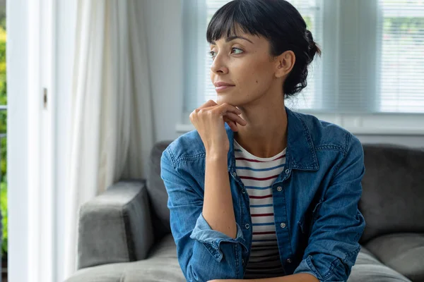 Besinnliche Kaukasische Junge Frau Die Daheim Mit Der Hand Kinn — Stockfoto