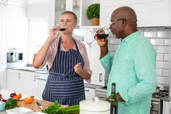 Mujer Caucásica Mayor Bebiendo Vino Con Hombre Afroamericano Mientras Cocina — Foto de Stock