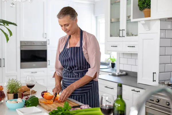 高级高加索女人在家里厨房做饭的时候切胡萝卜 生活方式 家庭生活 — 图库照片