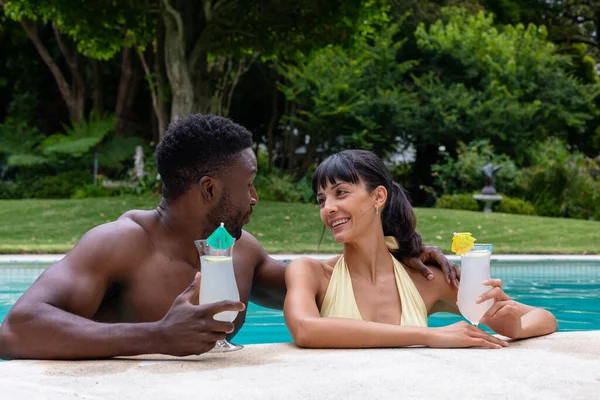 Smiling Multiracial Young Couple Enjoying Drinks Swimming Pool Unaltered Togetherness — Stockfoto