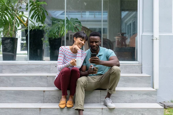 Caucasian Young Woman Looking African American Boyfriend Using Smart Phone — Foto de Stock