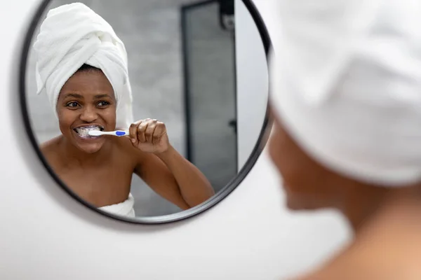 African American Mid Adult Woman Looking Mirror Brushing Teeth Bathroom — Stockfoto