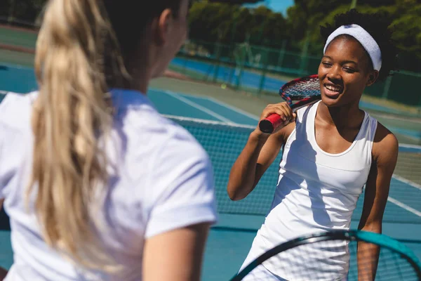 Smiling African American Female Player Talking Caucasian Athlete Tennis Court — стоковое фото