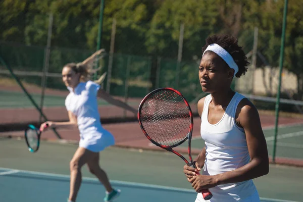 アフリカ系アメリカ人の女子テニス選手は 晴れた日にコートで2人のパートナーと一緒にプレーする 変更なしスポーツ競技テニスの概念 — ストック写真