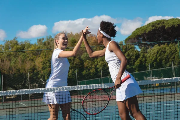 幸せな若い多人種の女性テニス選手は 晴れた日にコートで5以上のネットを与えます 変更なしスポーツ競技テニスの概念 — ストック写真