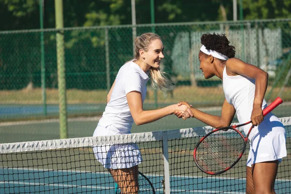 Happy Biracial Young Female Tennis Competitors Shaking Hands Net Court — Zdjęcie stockowe