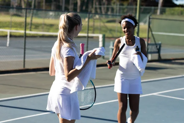 Lachende Vrouwelijke Multiraciale Spelers Met Handdoek Praten Tijdens Pauze Tennisbaan — Stockfoto