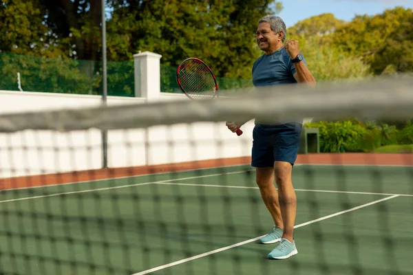 Alegre Biracial Senior Hombre Sosteniendo Raqueta Gesto Mientras Juega Tenis — Foto de Stock
