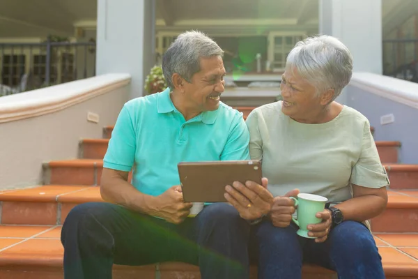 Smiling Biracial Senior Man Holding Digital Talking Wife Holding Cup — Stok fotoğraf