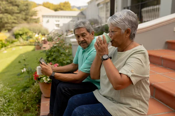 Biracial Senior Woman Drinking Coffee Senior Man Using Digital Tablet — Stockfoto