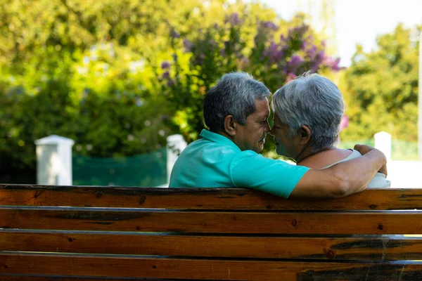 Romantic Biracial Senior Couple Looking Each Other While Sitting Bench — Stock fotografie