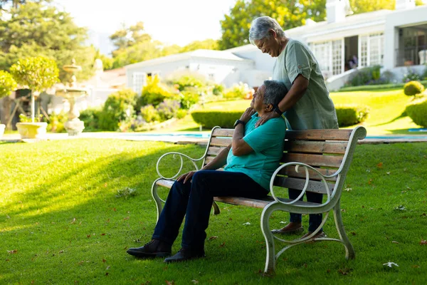 Cheerful Biracial Senior Woman Standing Looking Senior Husband Sitting Bench — Stock Photo, Image